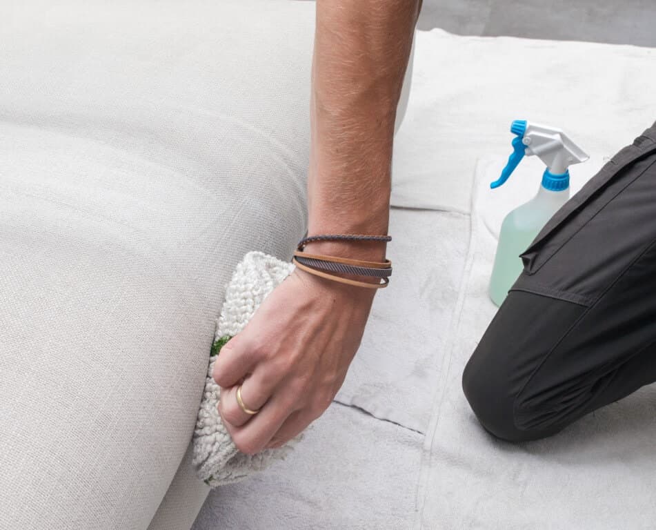 Close-up van voorbehandeling stoffen bank met reinigingsmiddel